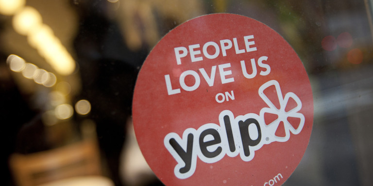 The Yelp Inc. logo is displayed in the window of a restaurant in New York, U.S., on Thursday, March 1, 2012. Yelp Inc., the site that lets users review everything from diners to dentists, is set to price it's IPO tonight and could potentially raise as much as $100 million, which would value the company at about $838 million. Photographer: Scott Eells/Bloomberg via Getty Images